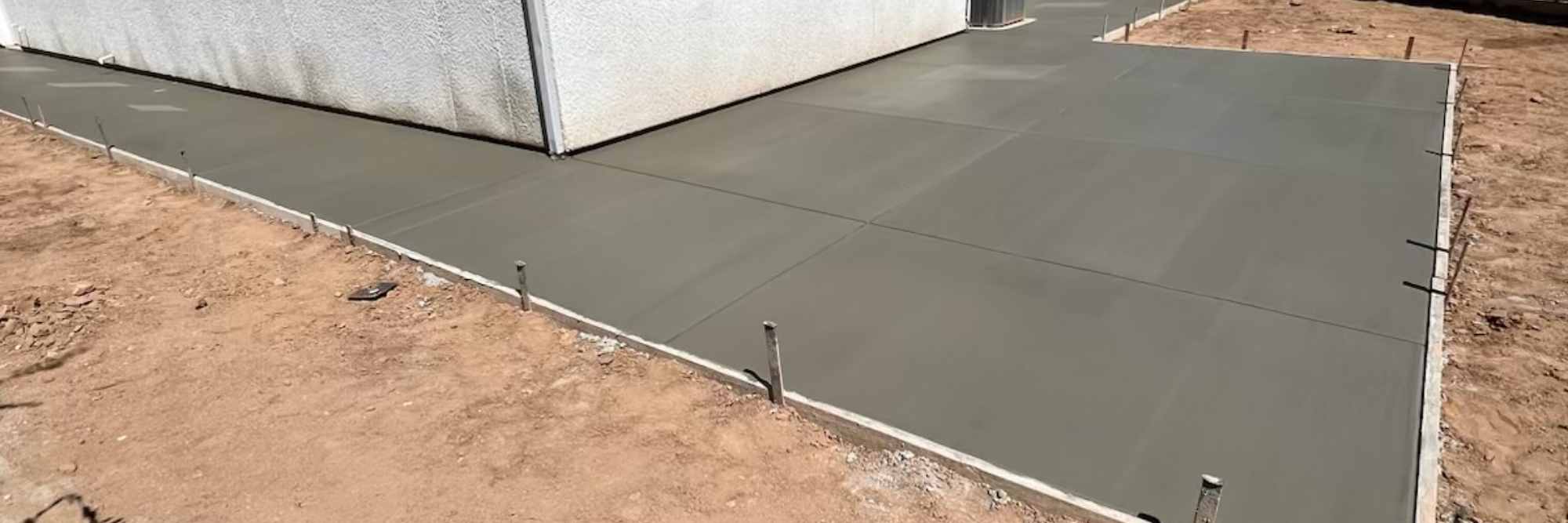 a backyard concrete patio surrounded by a new six foot wood fence